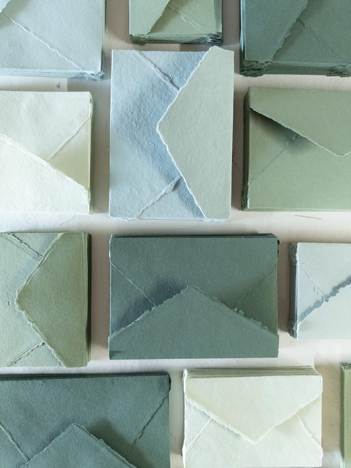 Set of handmade envelopes in assorted green shades: olive, sage, forest, and mint - crafted from high-quality cotton rag paper with a deckle edge