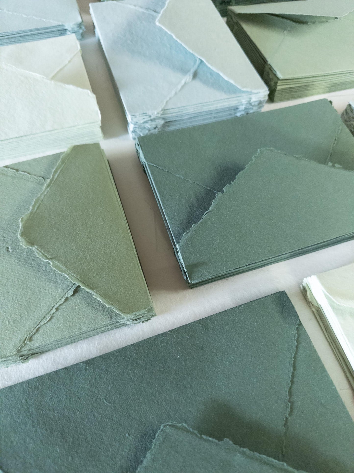 Set of handmade envelopes in assorted green shades: olive, sage, forest, and vintage - crafted from high-quality cotton rag paper with a deckle edge
