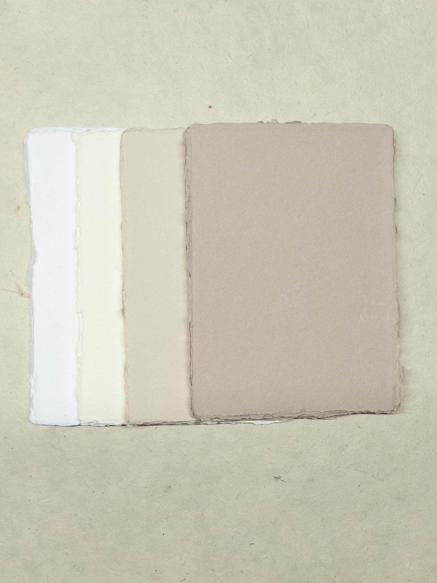 Beautiful beige paper and envelopes in assorted sizes, created with eco-friendly cotton rag material and a deckle edge - a sustainable choice for rustic and vintage-themed events
