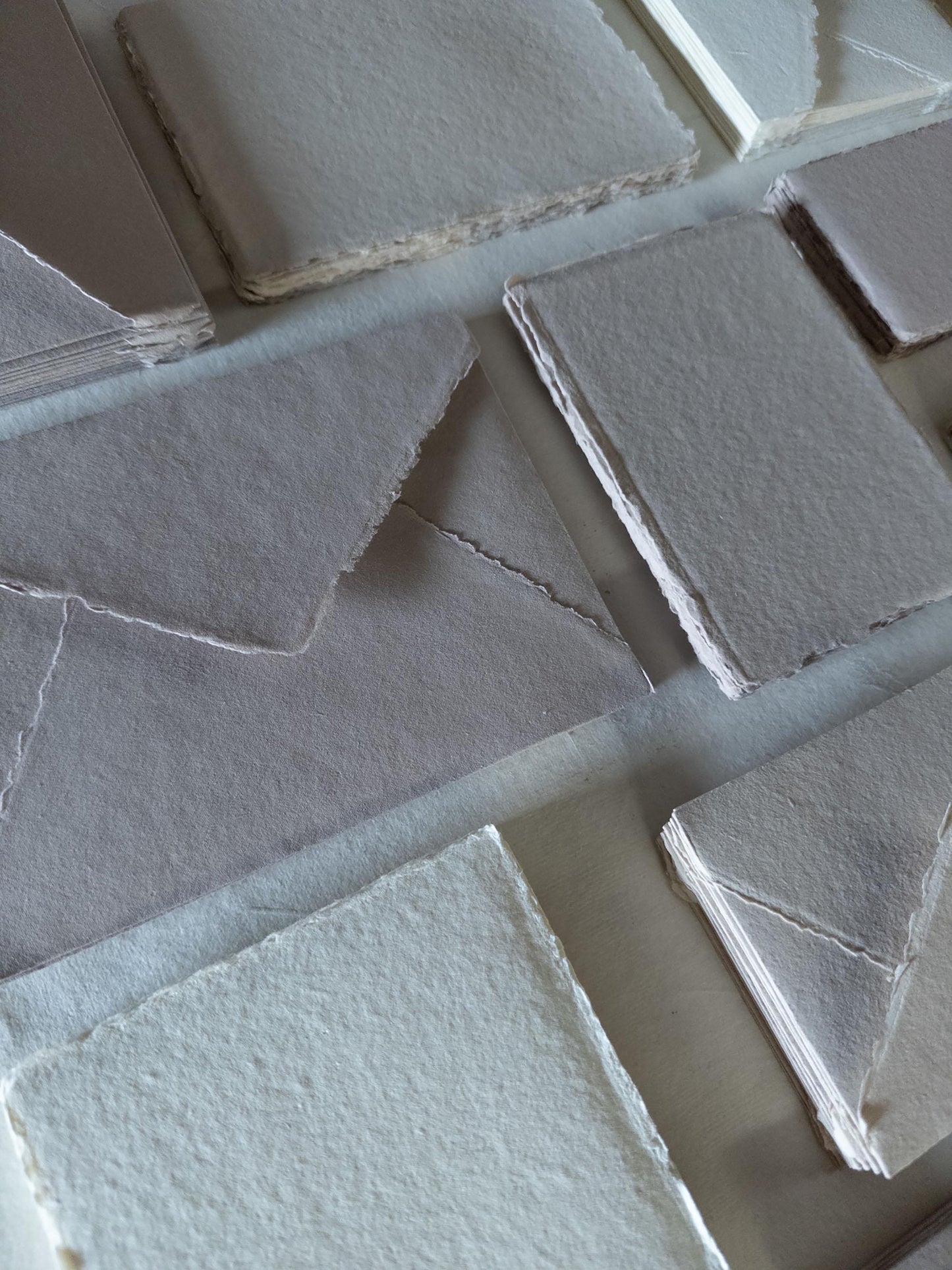 Set of handmade paper and envelopes in assorted natural colors: white, ivory, beige, and earth tones - available in various sizes and crafted from high-quality cotton rag material with a deckle edge